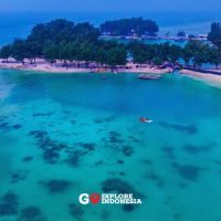 Pantai di Pulau Payung dengan hamparan pasir putih, air laut jernih berwarna biru kehijauan, dan suasana tropis yang tenang di Kepulauan Seribu.